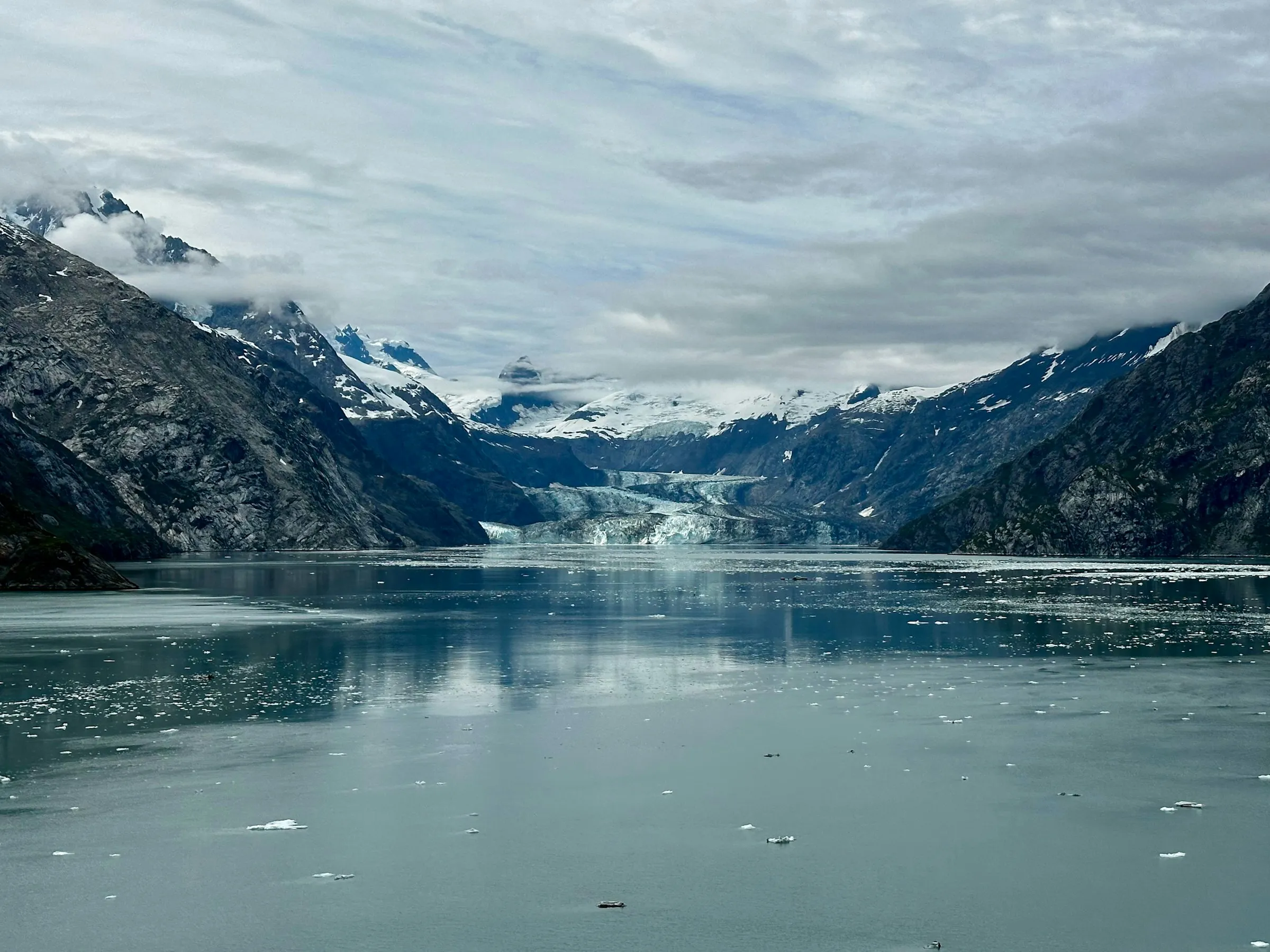 A tidewater glacier meeting a calm, icy Alaskan bay
