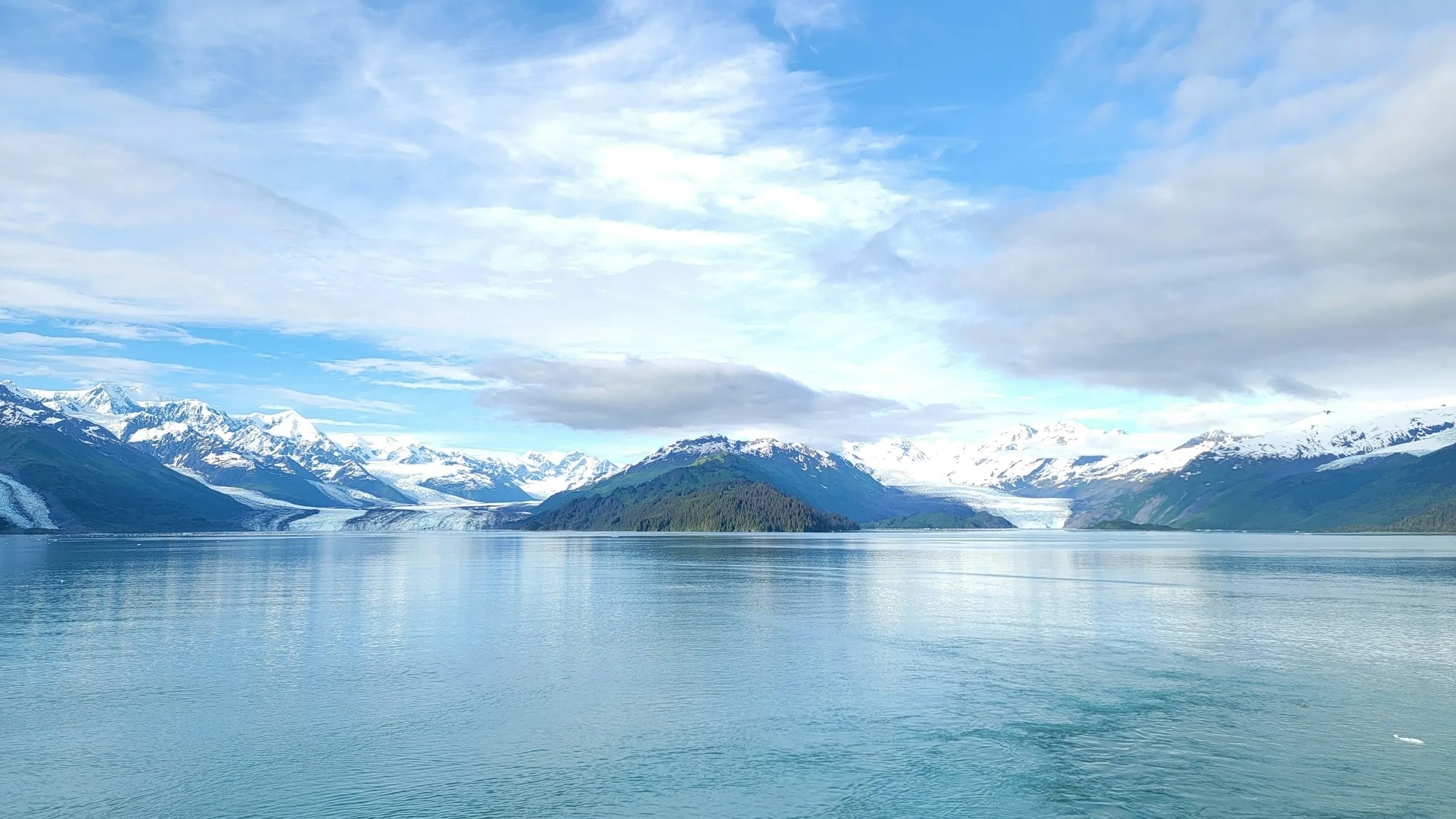 A wide glacier-fed bay in Alaska with snowy peaks and turquoise water