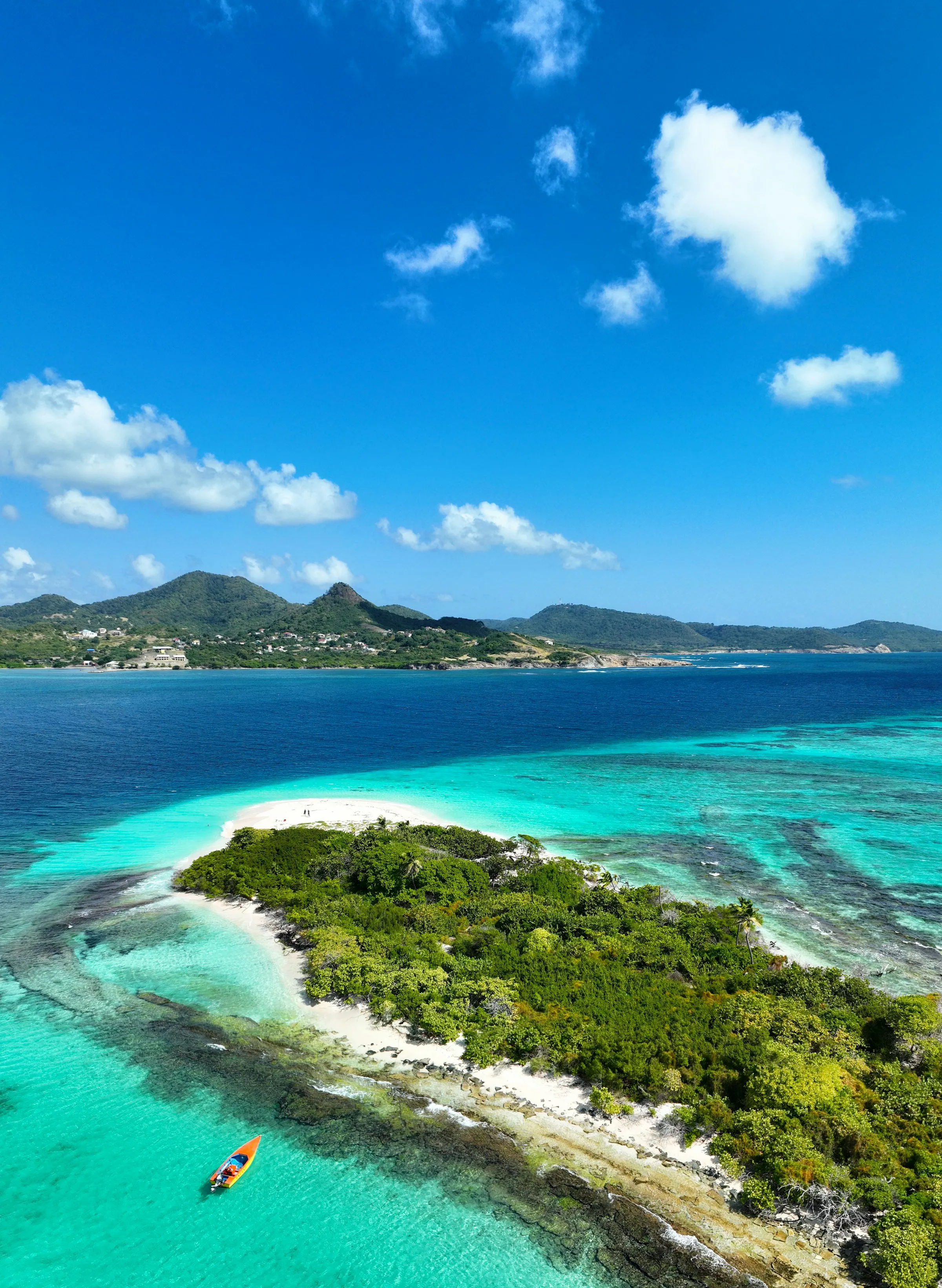A small green island with white beaches and clear water