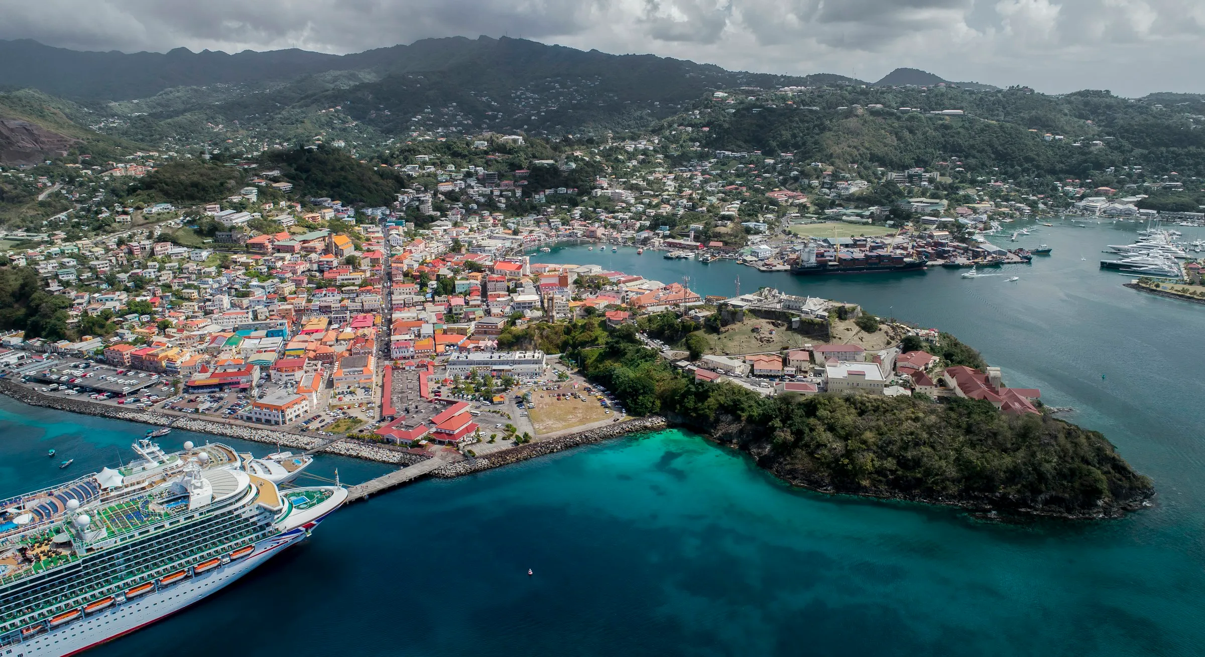 A cruise ship docked beside a colorful harbor town
