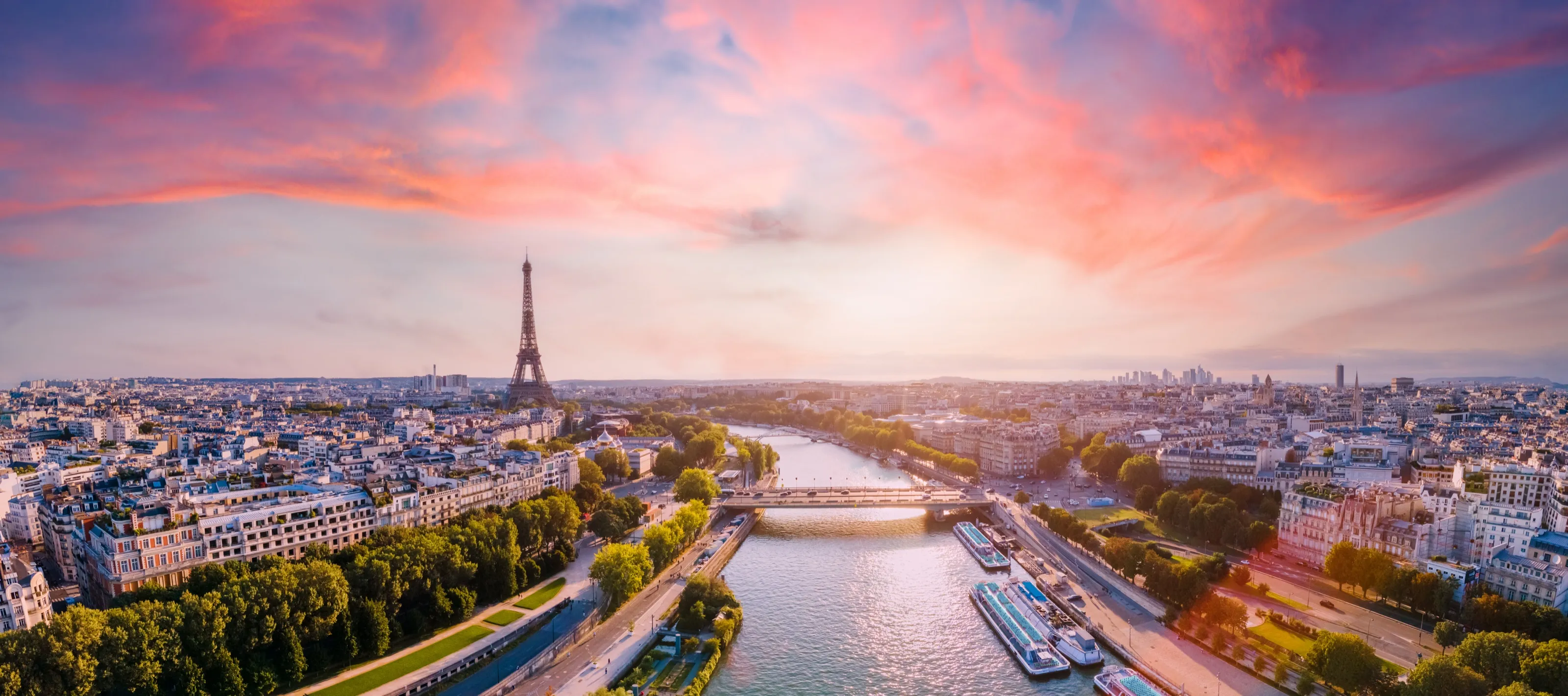 Aerial view over Paris rooftops and the Seine with the Eiffel Tower at sunset