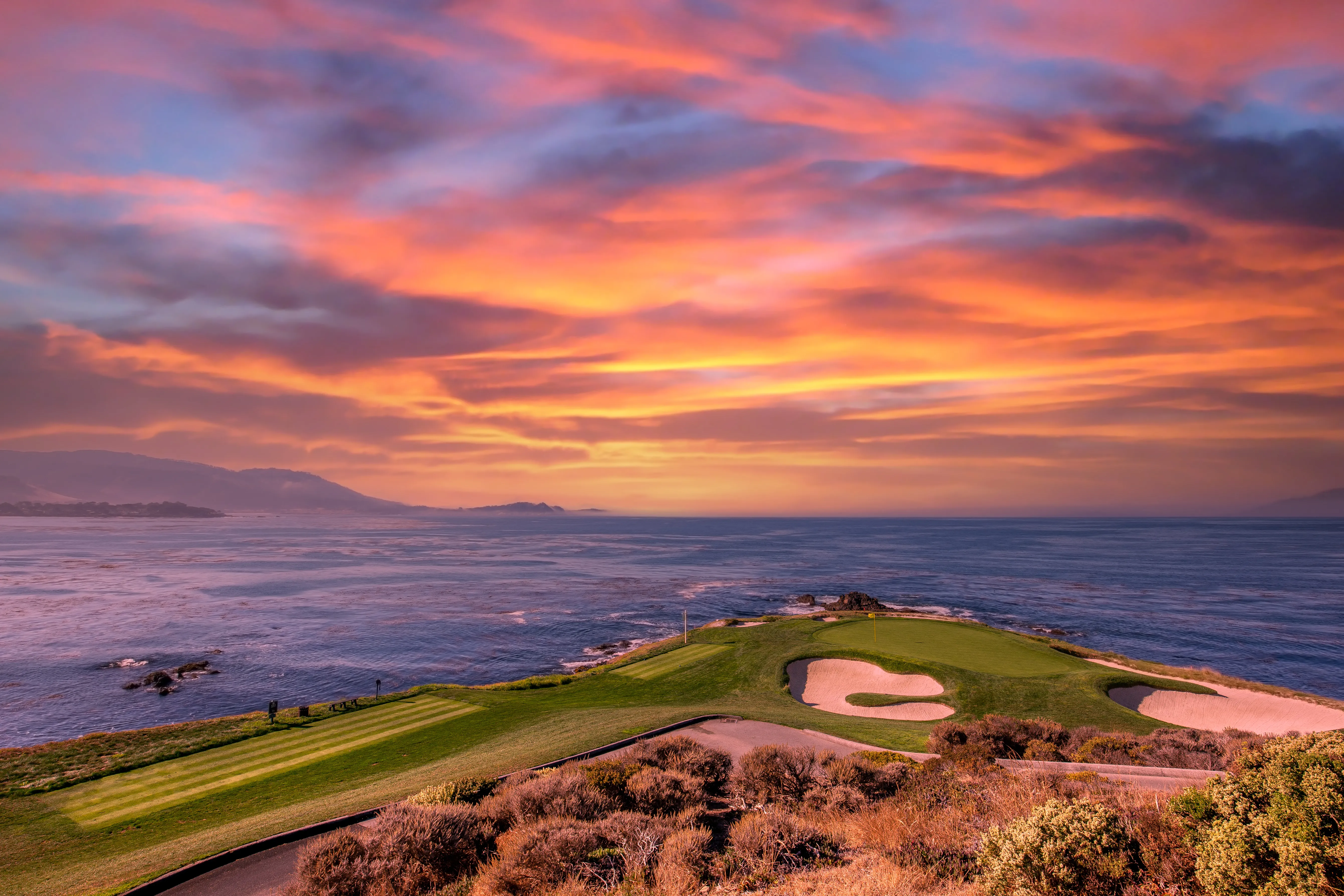 Aerial view of a cliffside golf hole above the Pacific