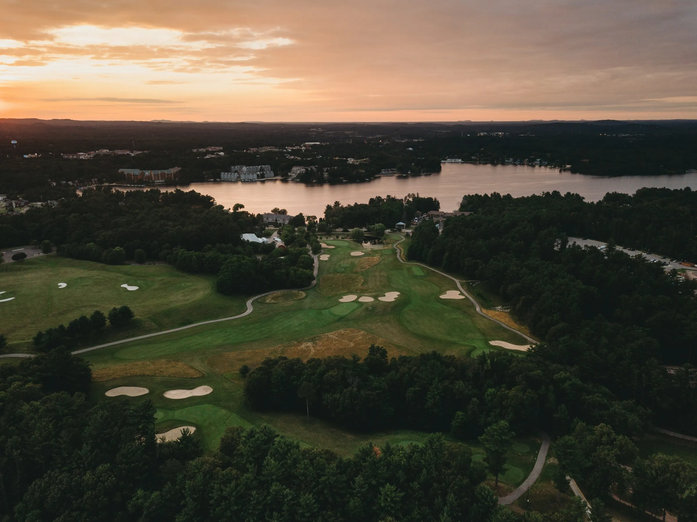 Aerial view of a wooded golf course at dusk
