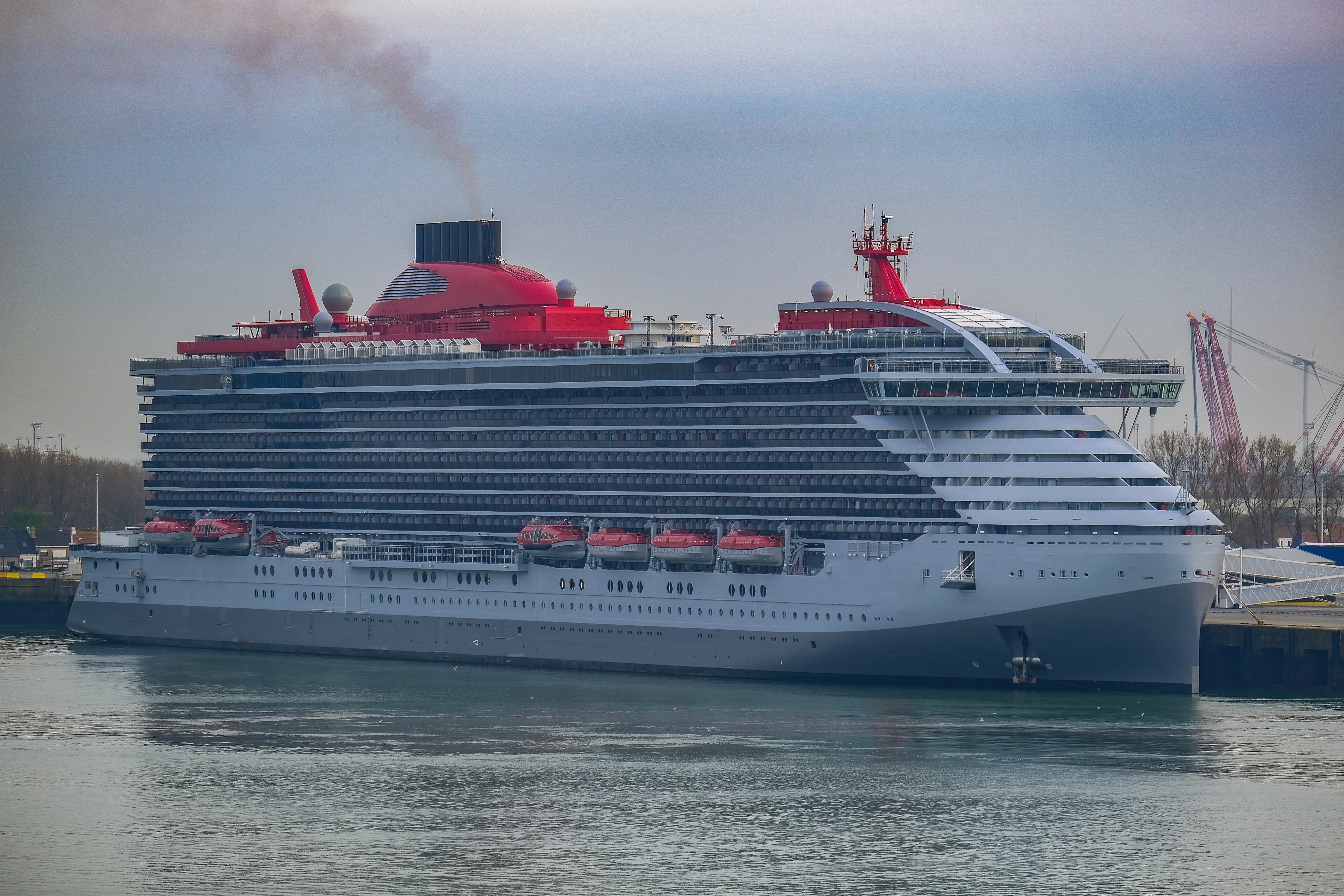Virgin Voyages' Scarlet Lady with its red funnel in port